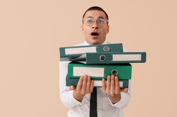 Wall Mural - Stressed businessman with folders on beige background