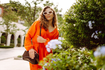 Wall Mural - Young beautiful woman in trendy summer dress having fun on street of old town. Girl travels during student vacation holidays. Concept of lifestyle, fashion, travel.