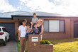 © Austockphoto - portrait of mixed race Chinese Australian family outside home with kids sitting on mailbox