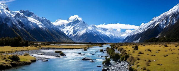 Wall Mural - snow - capped mountains and river surrounded by lush green trees under a clear blue sky with a single white cloud
