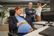 © Михаил Решетников - A pregnant woman sleeps at her workplace. Colleagues look disapprovingly.