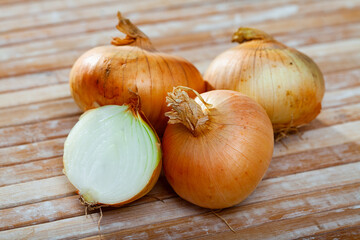 Wall Mural - Agricultural production, fresh raw bulbs onion on wooden table