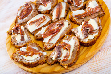 Wall Mural - Traditional Spanish pickled anchovy fillets served on sliced grain bread with butter