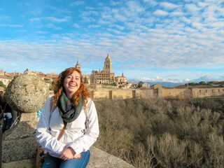 Smiling person in front of Segovia with cathedral and blue sky