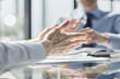 © Katsiaryna - Focus on the hand of a manager who is gesturing while discussing project details with colleagues, talking about contract terms with clients.