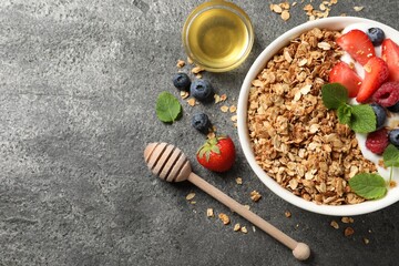 Canvas Print - Tasty granola with berries, yogurt and honey on grey textured table, flat lay. Space for text