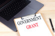 © Iryna - GOVERNMENT GRANT text on clipboard on laptop