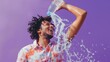 © Nadin Faust - photo of an attractive african american man in his mid-20s, pouring water from the bottle onto himself and laughing heartily against a purple background