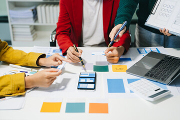 Wall Mural - close up view of ui developer team brainstorming on their project with laptop, smartphone and digita