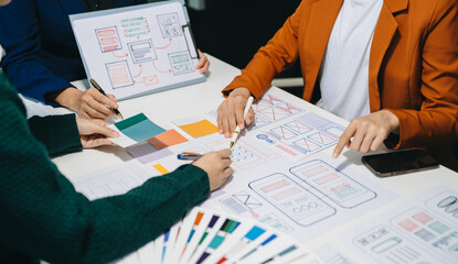 Wall Mural - close up view of ui developer team brainstorming on their project with laptop, smartphone and digita