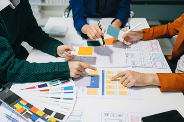 Wall Mural - close up view of ui developer team brainstorming on their project with laptop, smartphone and digita
