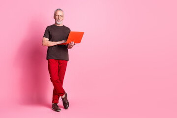 Wall Mural - Full size photo of nice man with beard dressed t-shirt in glasses hold laptop stand near empty space isolated on pink color background