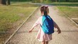 © maxximmm - back to school. a little girl with a backpack runs through the green park to school along the path. education kid dream concept. a small child with a backpack back view runs the park to sun school