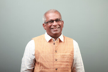 Wall Mural - Portrait of a smiling Indian elderly man wearing ethnic dress