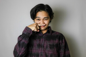 Portrait of an Asian Indonesian young man wearing a purple shirt with a random expression when photographed with an isolated white background