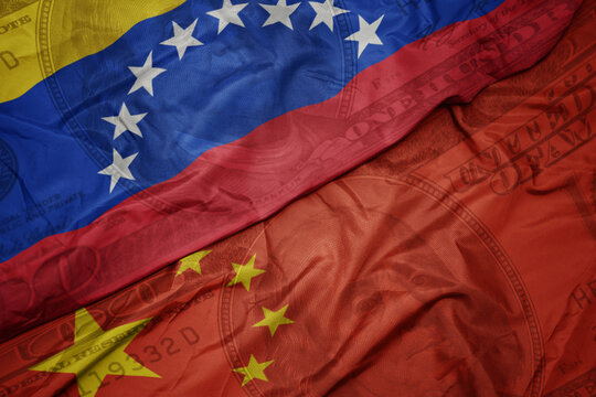 waving colorful flag of venezuela and national flag of china on the dollar money background. finance concept.