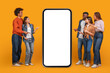 © Prostock-studio - A group of five friends stand in front of a large smartphone with a blank white screen. They are all pointing at the screen, suggesting they are interested in what is being displayed