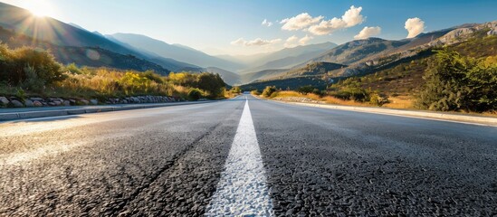 Wall Mural - Asphalt road in the mountains with soft sky on the background. Copy space image. Place for adding text or design