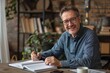 © Straxer - Smiling adult man with glasses studying on wooden table writing in a book.
