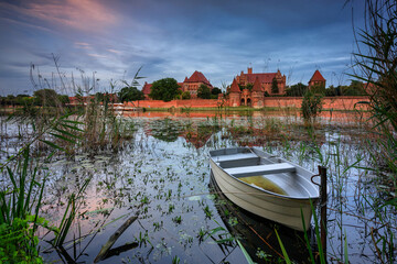 Wall Mural - Castle of theTeutonic Order in Malbork by the Nogat river at sunset.