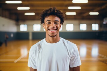 Sticker - Smiling portrait of a male teenager in basketball gym