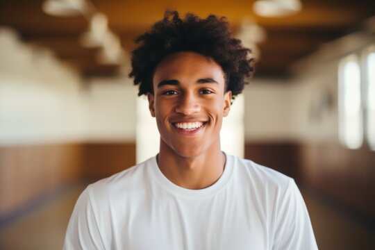 Smiling portrait of a male teenager in basketball gym