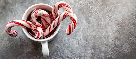 Poster - Red and white candy canes in a cup on a gray pastel background. with copy space image. Place for adding text or design