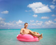 © Ljupco Smokovski - Handsome young man sitting on a swimming ring
