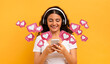© Prostock-studio - Happy pretty young indian woman student using smartphone and wireless headphones isolated on yellow studio background, have video call with lover
