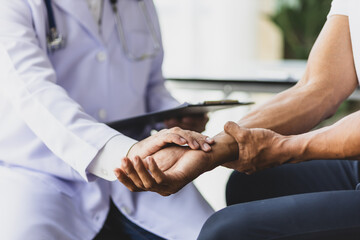 Man with arm pain, wrist pain and shoulder pain is seeing a doctor for diagnosis in an examination room at a hospital.