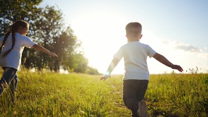 Wall Mural - happy family kids. people in the park children child running together in the park at sunset silhouette. mom dad daughter and son are run happy family and little child in summer. dream kids fun run