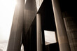 © yaqui_villegas - Abstract composition focusing on the structural pillars of a skyscraper in Rotterdam, presenting a dramatic play of light, shadow, and form