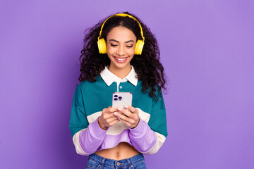 portrait of lovely young girl smart phone headphones wear shirt isolated on purple color background
