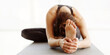 © Prostock-studio - A woman is engaging in a yoga session, stretching forward while seated on a mat indoors. She appears focused and calm, embodying mindfulness and concentration during her morning practice.