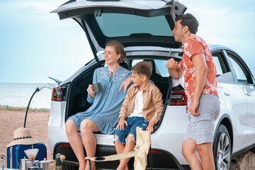 Wall Mural - Family vacation trip traveling by the beach with electric car, happy family recharge EV car, enjoying outdoor camping coffee. Seascape travel and eco-friendly car for clean environment. Perpetual