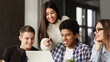 © Prostock-studio - College students using laptop in library, studying together for school assignment
