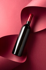 Wall Mural - Bottle of red wine on a red background.