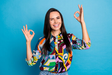 Wall Mural - Photo portrait of attractive young woman wink show okey dressed stylish colorful print clothes isolated on blue color background