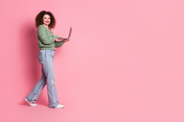 Wall Mural - Photo of cheerful gorgeous woman wear trendy khaki clothes hold device empty space isolated on pink color background