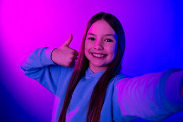 Sticker - Photo of shiny attractive little lady dressed hoodie recording video showing thumb up isolated neon pink color background