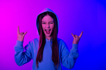 Sticker - Photo of cheerful cool little lady dressed hoodie showing hard rock signs empty space isolated neon purple color background