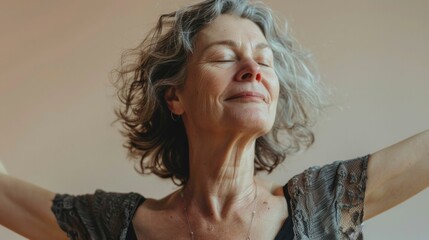 Poster - Elderly woman with closed eyes smiling and arms outstretched wearing a lace top with a necklace against a soft-focus beige background.