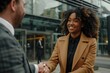 © darshika - Smiling young black business woman shaking hands with a white business man