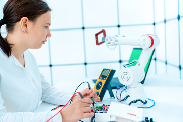 Sticker - Young woman student in the laboratory for the development and design of industrial robots