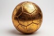 © Aaron Weiss - A gold soccer ball with a shiny surface. The ball is sitting on a white background. The gold color of the ball gives it a luxurious and elegant appearance