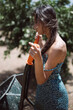 © teksomolika - Woman outdoors in summer with pump, showcasing rustic charm and sustainable lifestyle