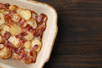 Wall Mural - Delicious baked potatoes and bacon in baking dish on wooden table, top view. Space for text