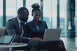 © Ivan - Two black entrepreneurs using a laptop together in the office