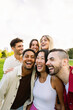 © Xavier Lorenzo - Vertical photo of happy young group of millennial friends having fun together outdoor. Millennial student people laughing, enjoying public holiday at city street.