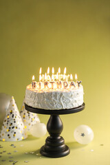 Wall Mural - Tasty birthday cake with burning candles on green background